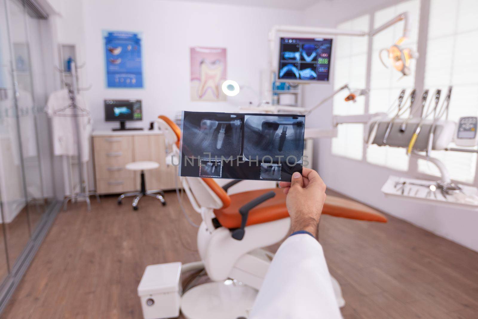 Radiologist dentist doctor holding medical teeth radiography working in stomatology hospital office examination room. Specialist orthodontist analyzing tooth jaw after oral dental surgery