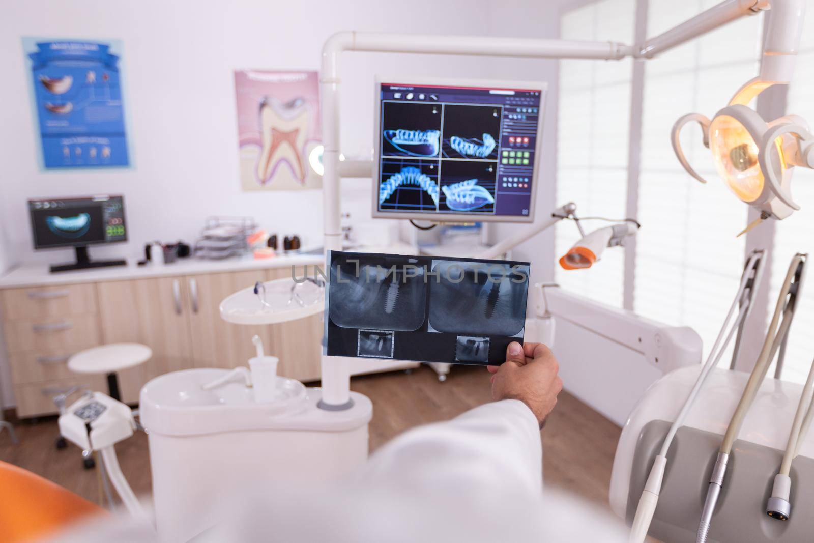 Radiologist man doctor comparing medical teeth radiography expertise with oral dental xray on monitor planning teethcare treatment. Orthodontist working in stomatology hospital office room