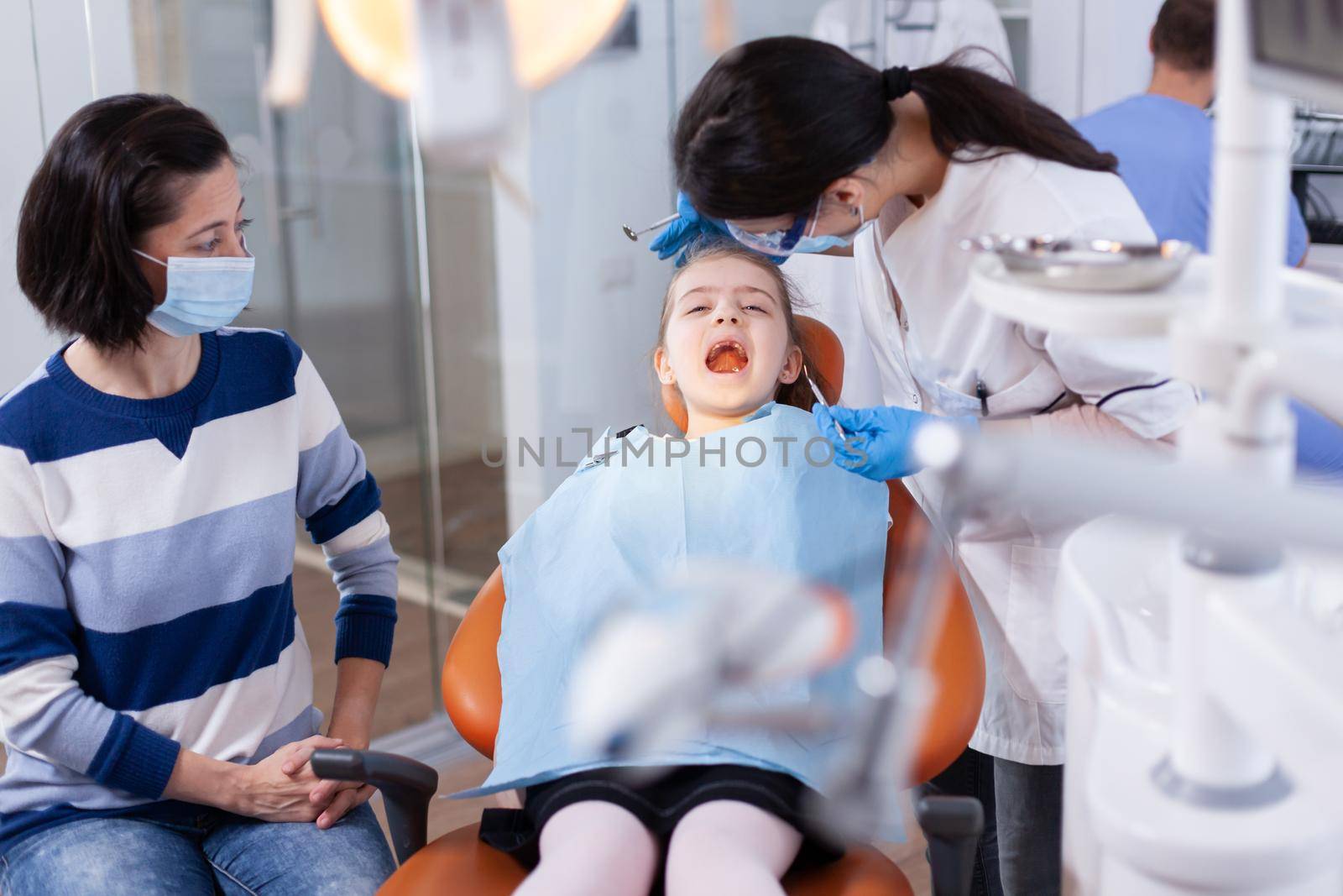 Dentist using modern dental equipment by DCStudio