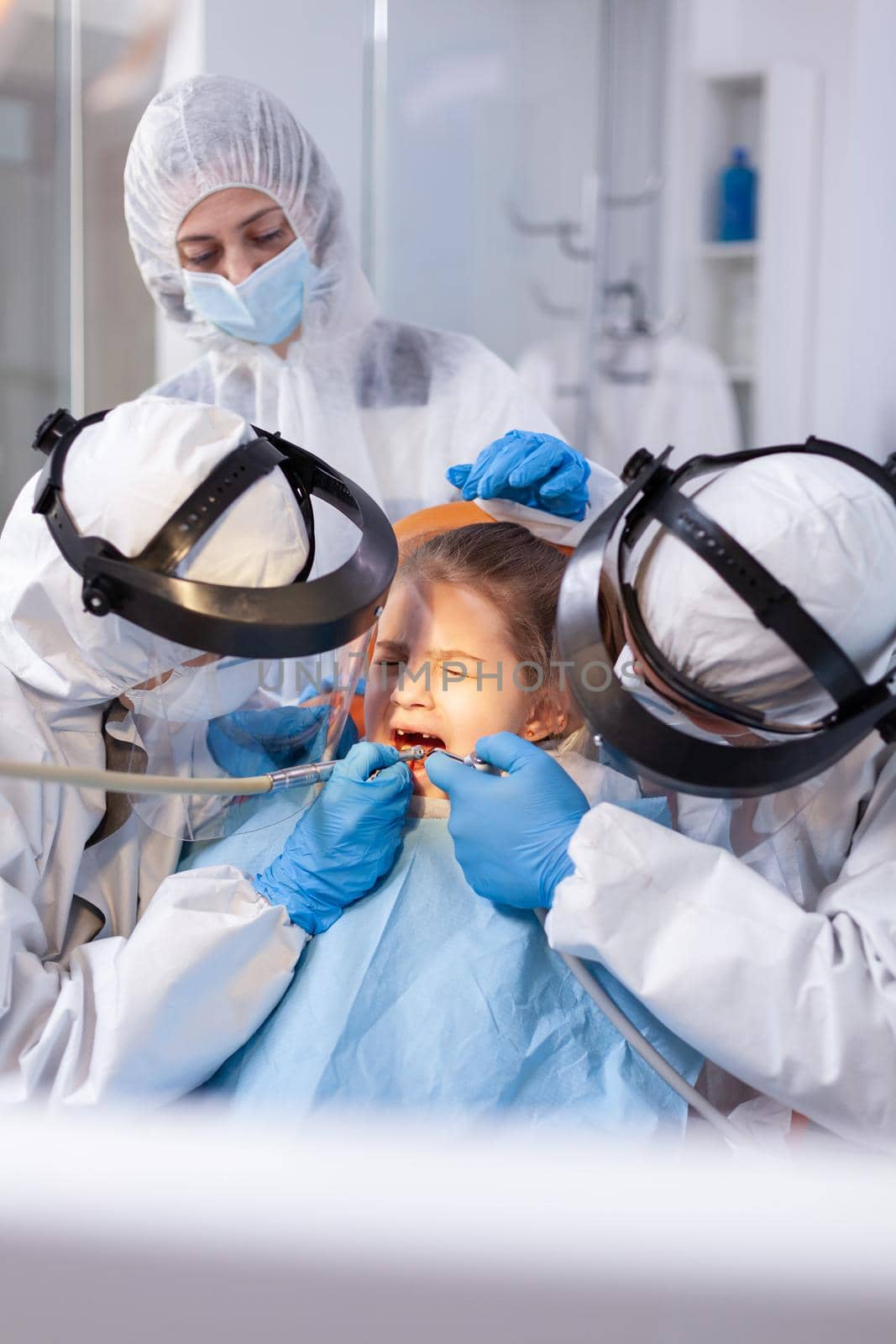 Little girl in the course of painfull caries treatment by DCStudio