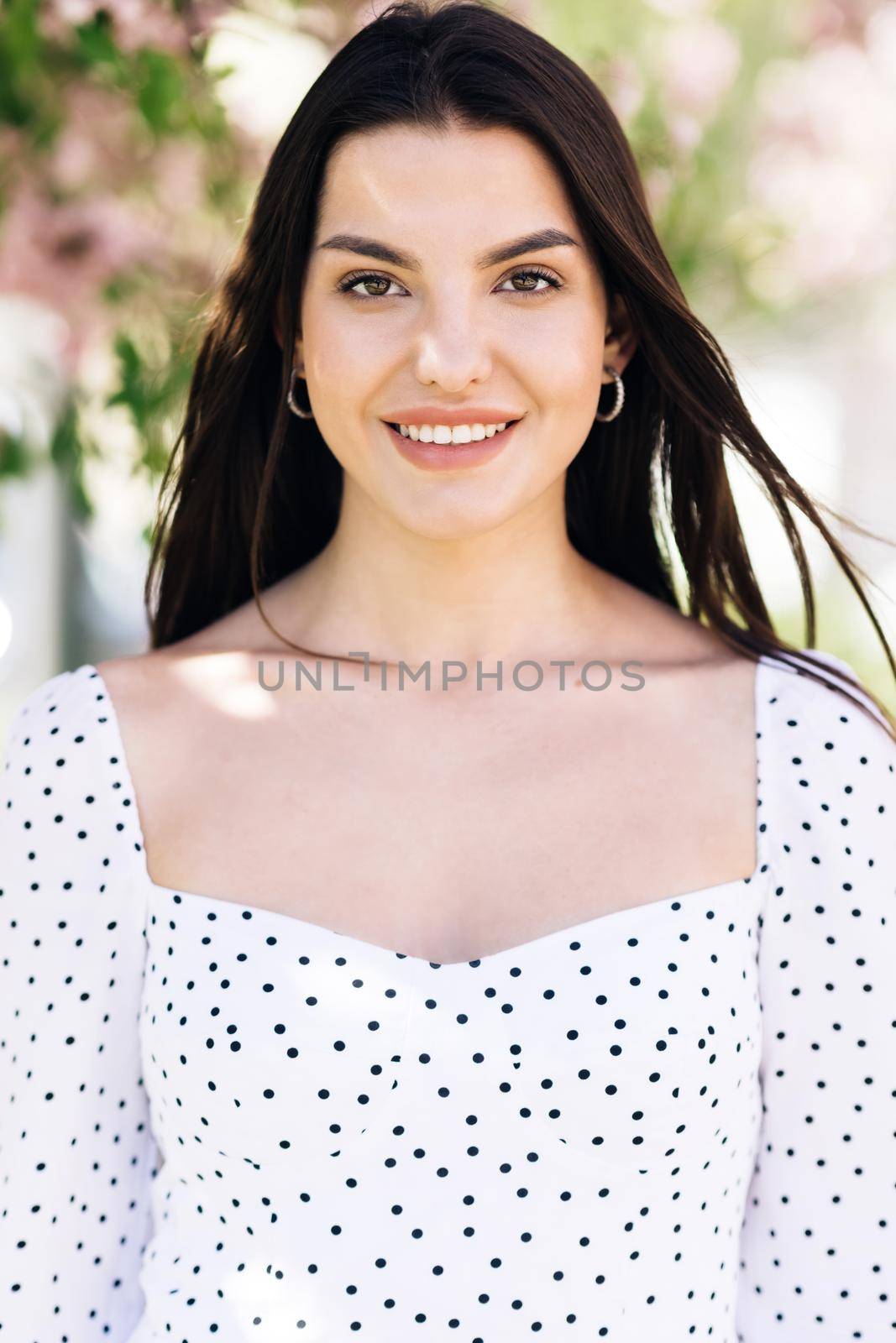 Beautiful Female with creative vivid makeup and pink lipstick on lips and hairstyle posing outside happy looking at camera. Close up portrait Smiling attractive young adult woman