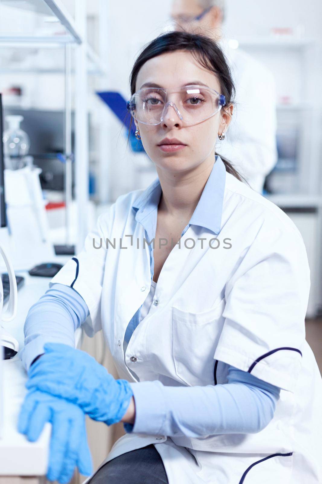 Successful scientist in genetics looking at camera in research laboratory Chemist wearing lab coat using modern technology during scientific experiment in sterile environment.