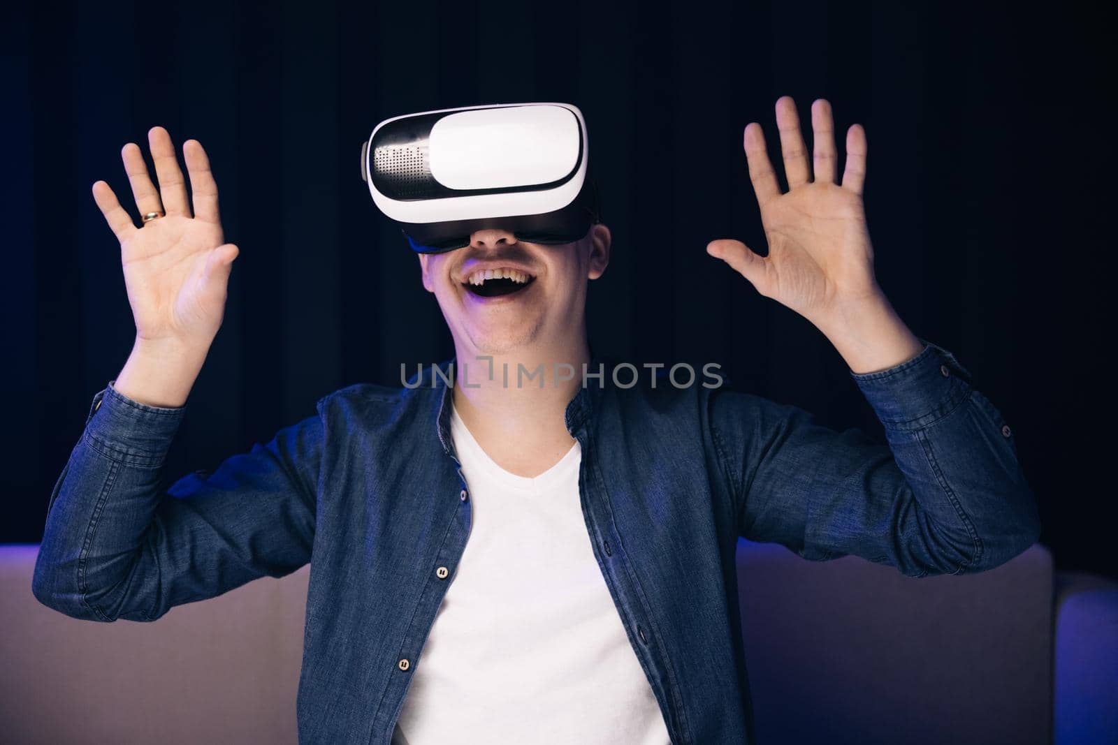 Handsome man wearing virtual reality headset. Creative man touch something using modern 3D vr glasses indoors. Augmented Reality. Freelancer student playing using VR glasses by uflypro