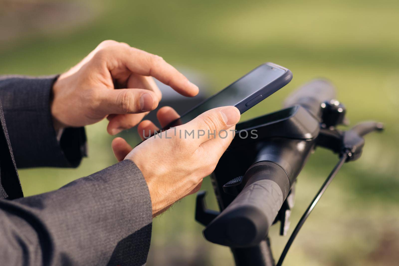 Close-up of hands with phone. Tourist taking e-scooter or bicycle. Phone application for rental scooter. Ecological city transport. Businessman rents electric scooter using mobile phone app. by uflypro