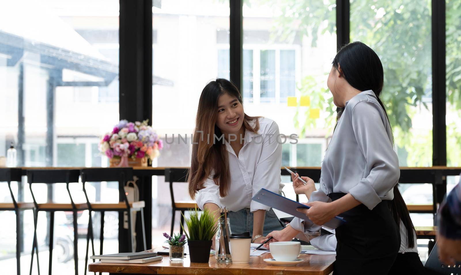Group of Asian Business People with casual suit are working with a financial for marketing in the modern Office or coffee shop, Business marketing concept.