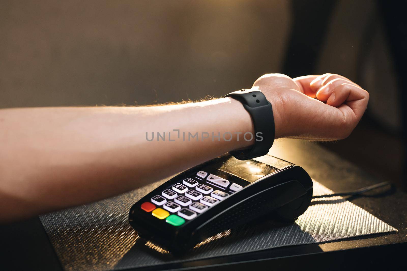 Man is Paying with a Smart Watch. Contactless technology NFC. Person pays in a cafe using an electronic smart watch. Online shopping using modern technology. Consumerism internet online purchases by uflypro