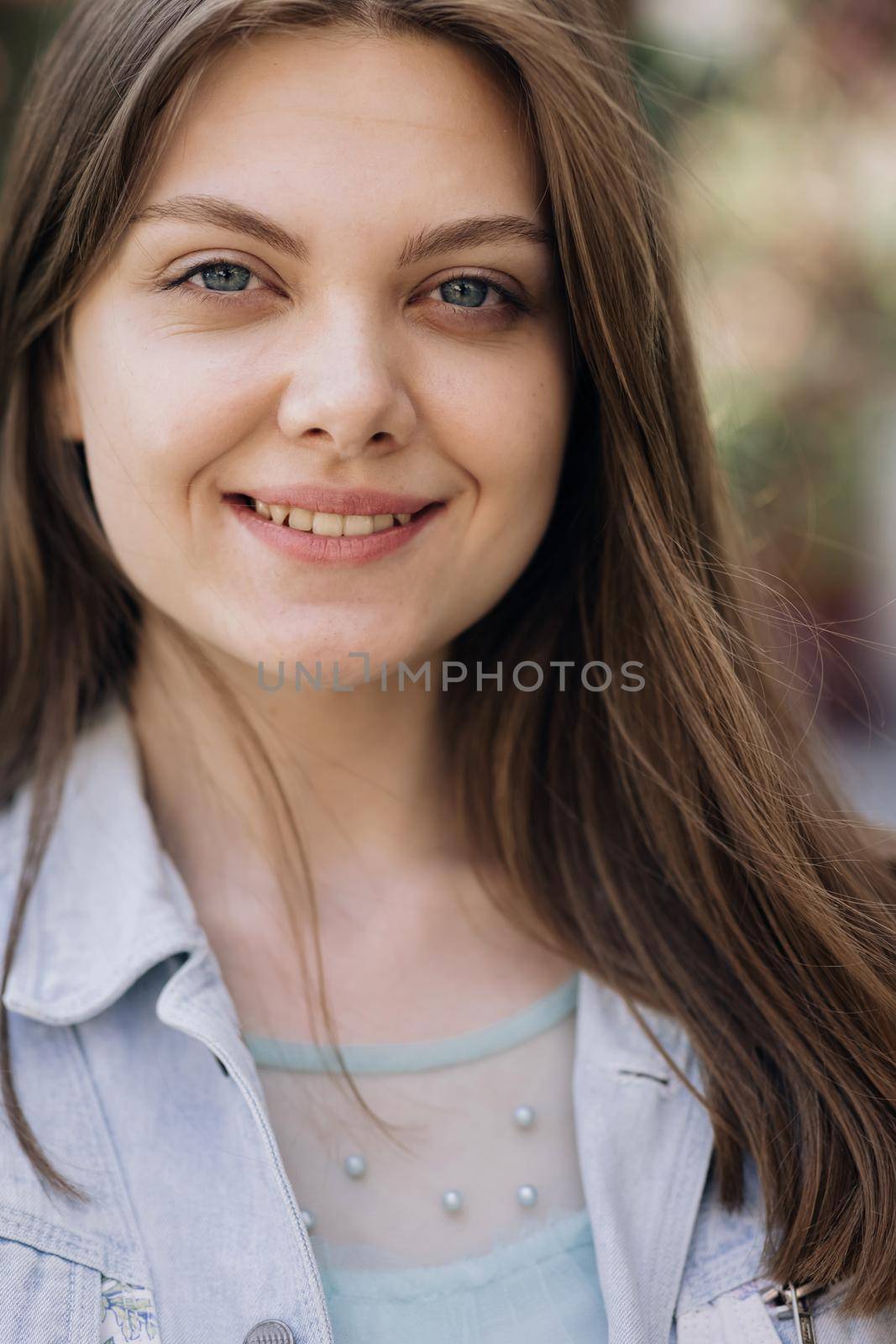 Vertical Screen Beautiful Female with creative vivid makeup and pink lipstick on lips and hairstyle posing outside happy looking at camera. Close up portrait Smiling attractive young adult woman. by uflypro