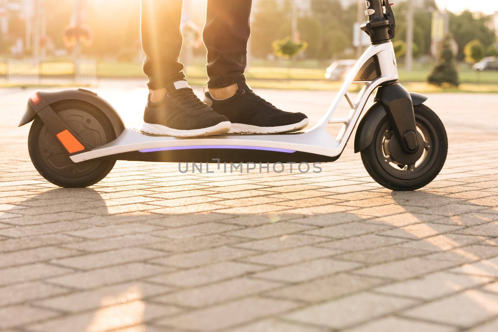 Man Ride On Electric Scooter Mobility. E-Scooter Rider Rent Personal Eco Transport. Driving Ecology Transportation. Male Drive Electric Scooter In City. Urban Style Riding Ecological Transport Travel by uflypro