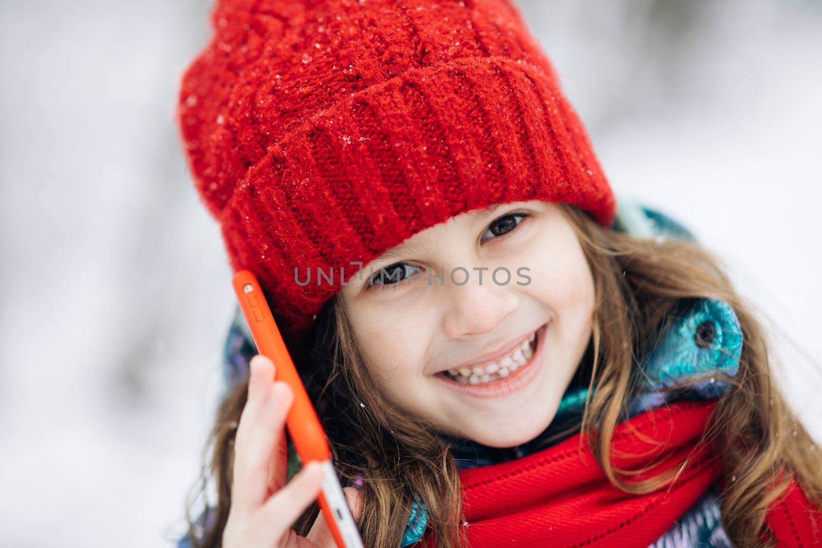 Close up of young beautiful woman in winter hat talking emotionally and surprised talking on cell phone. by uflypro