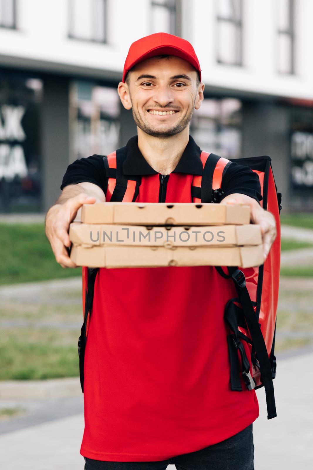 Portrait of delivery man with hot pizza boxes waiting for customer. Home delivery. Fast food convenience delivery and transportation. Concept of courier, home delivery, e-commerce, pizza