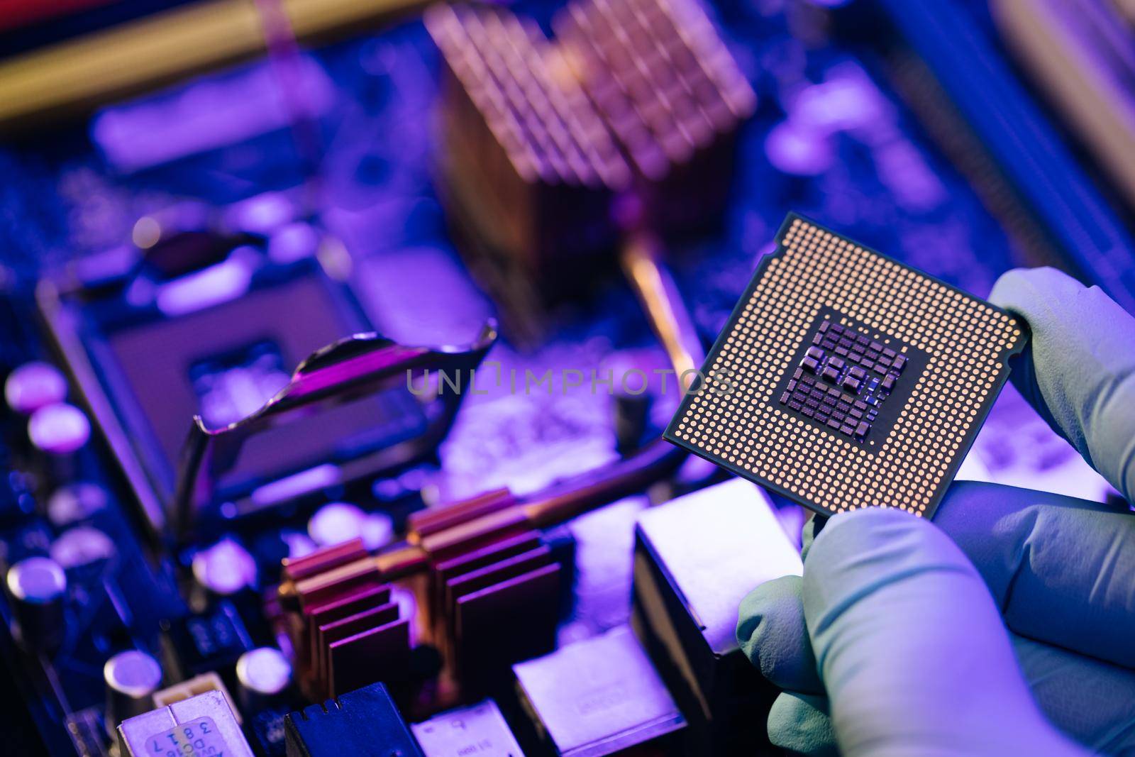 Engineer showing a computer microchip on motherboard background. Electronic circuit board with processor.