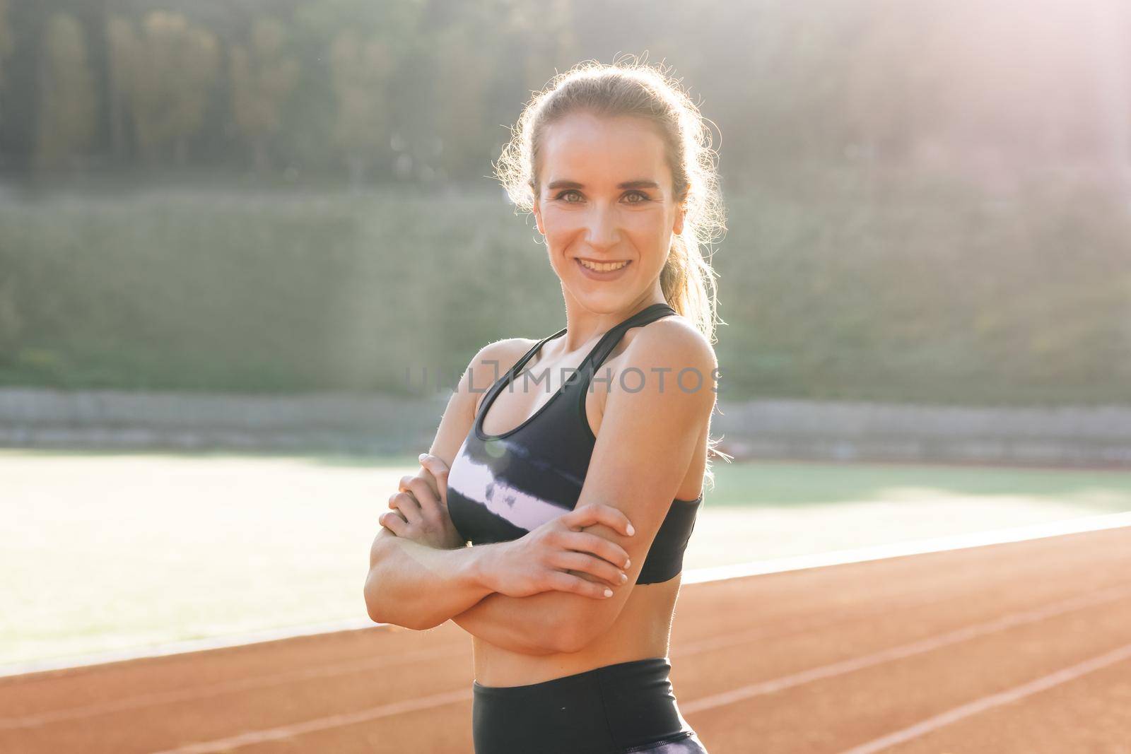 Trainer girl resting outdoor after power workout and physical activity. Portrait of fitness woman in sport clothes professional athlete looking at camera after physical training. Sports and workout.