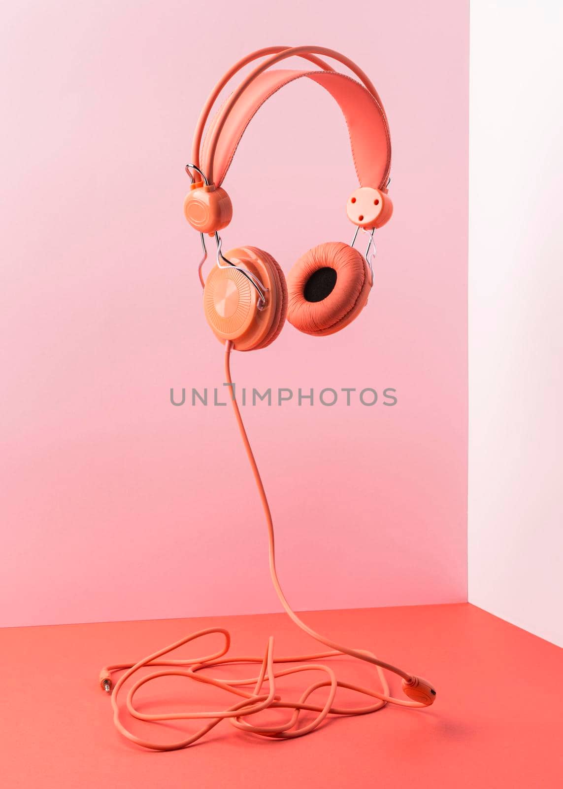 pink headphones with cable flying. High quality photo by Zahard