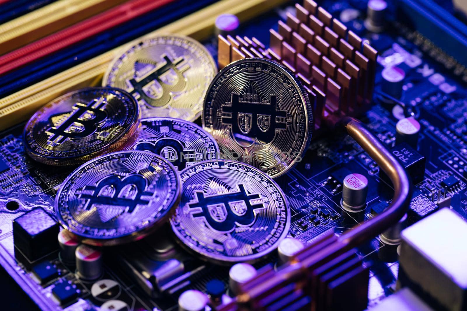 Crypto currency, bitcoin. BTC, Bit Coin. Blockchain technology, bitcoin mining. Close up shot of Bitcoins coins isolated on motherboard background by uflypro