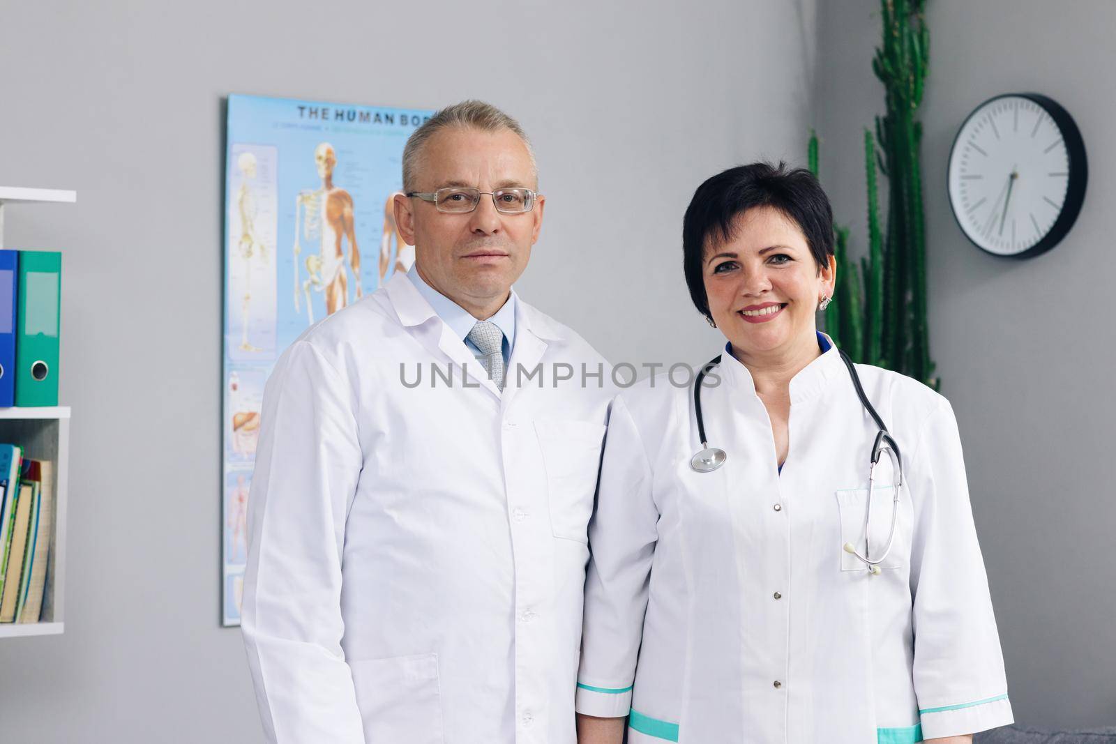 Woman and man doctors. International medics healthcare workers. Physicians and nurses looking at camera. Clinic team. Docs at work in hospital by uflypro