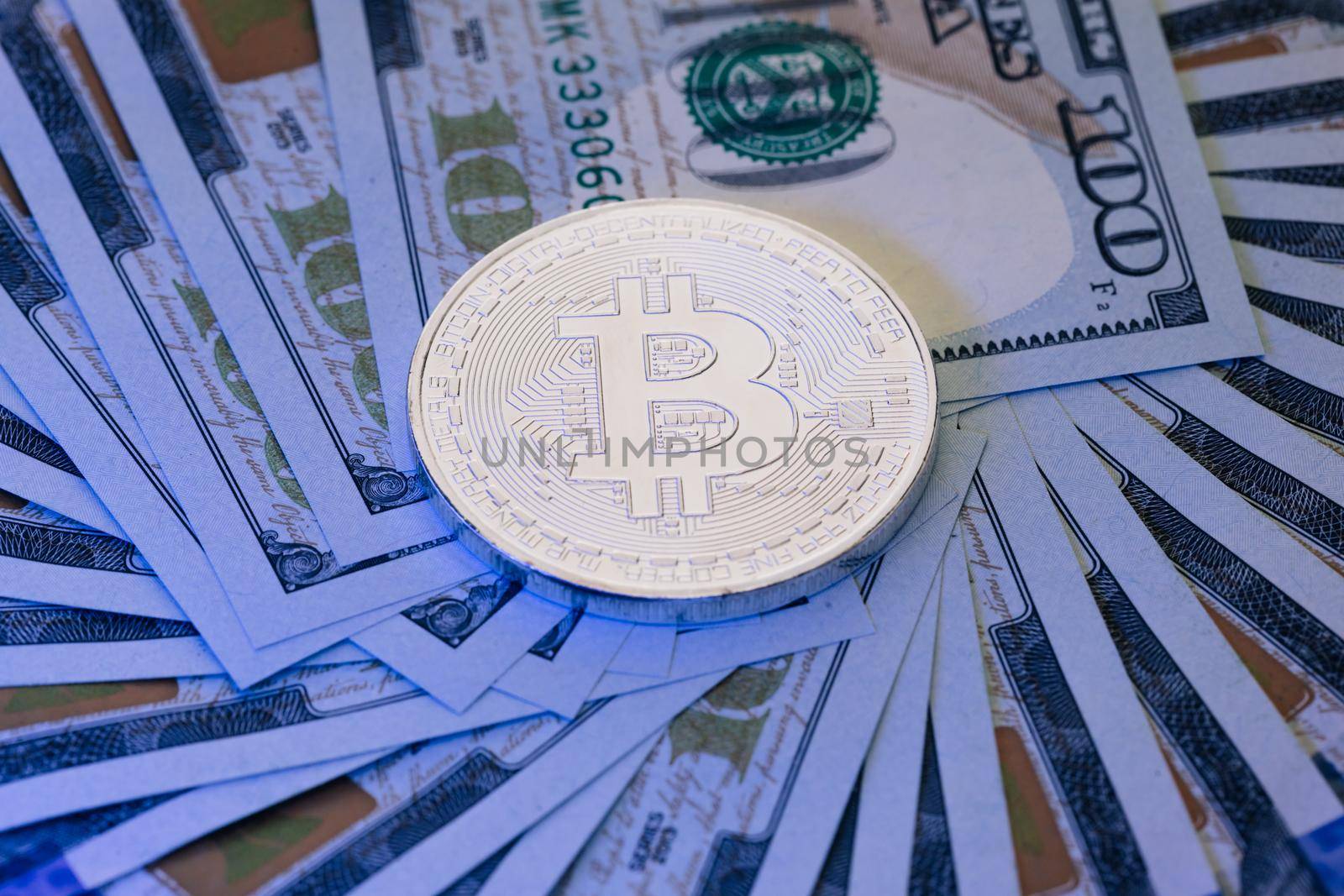 Bitcoin crypto currency stacked with 100 dollar bills. New worldwide virtual internet money with USA banknotes. Diferent physical metal currency over 100 dollar bill of United States by uflypro