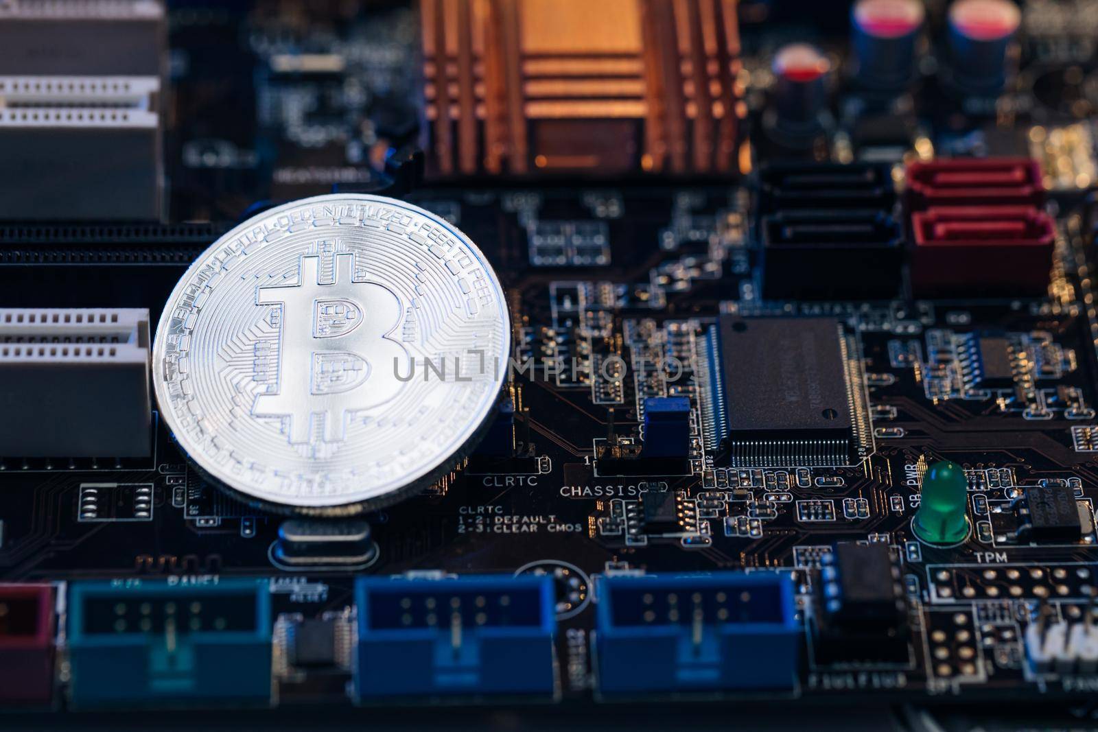 Bitcoin. Crypto currency Silver Bitcoin, BTC, Bit Coin. Macro shot of Bitcoin coins isolated on motherboard background.