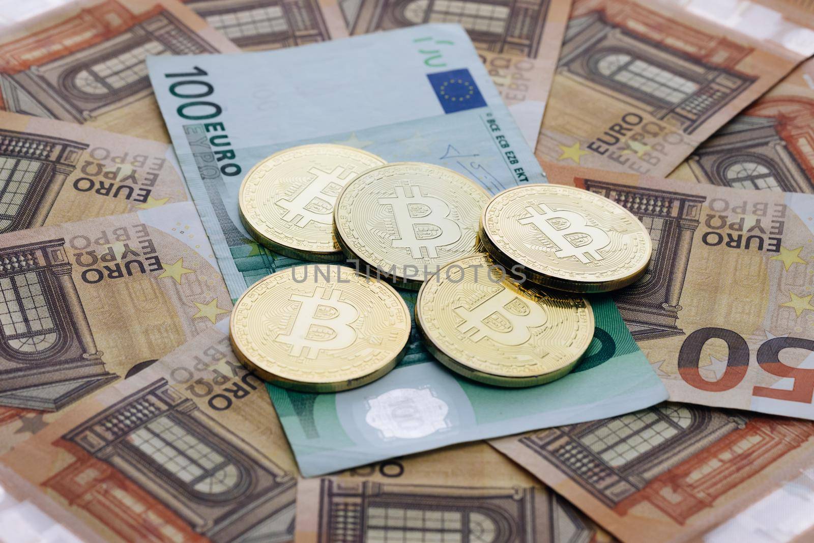 Coin with symbol of cryptocurrency of bitcoin lies on real banknotes of European Union, euro, new money, exchange of digital money for euro, gold coin, new economy. Euro banknotes. Euro bills. by uflypro