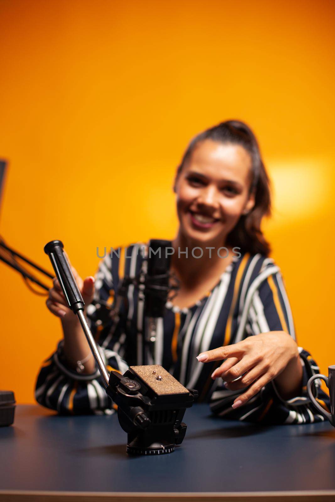 Videographer pointing at fluid head for tripod while recording video for followers on social media. Social media star making online internet content about video equipment for web subscribers , film