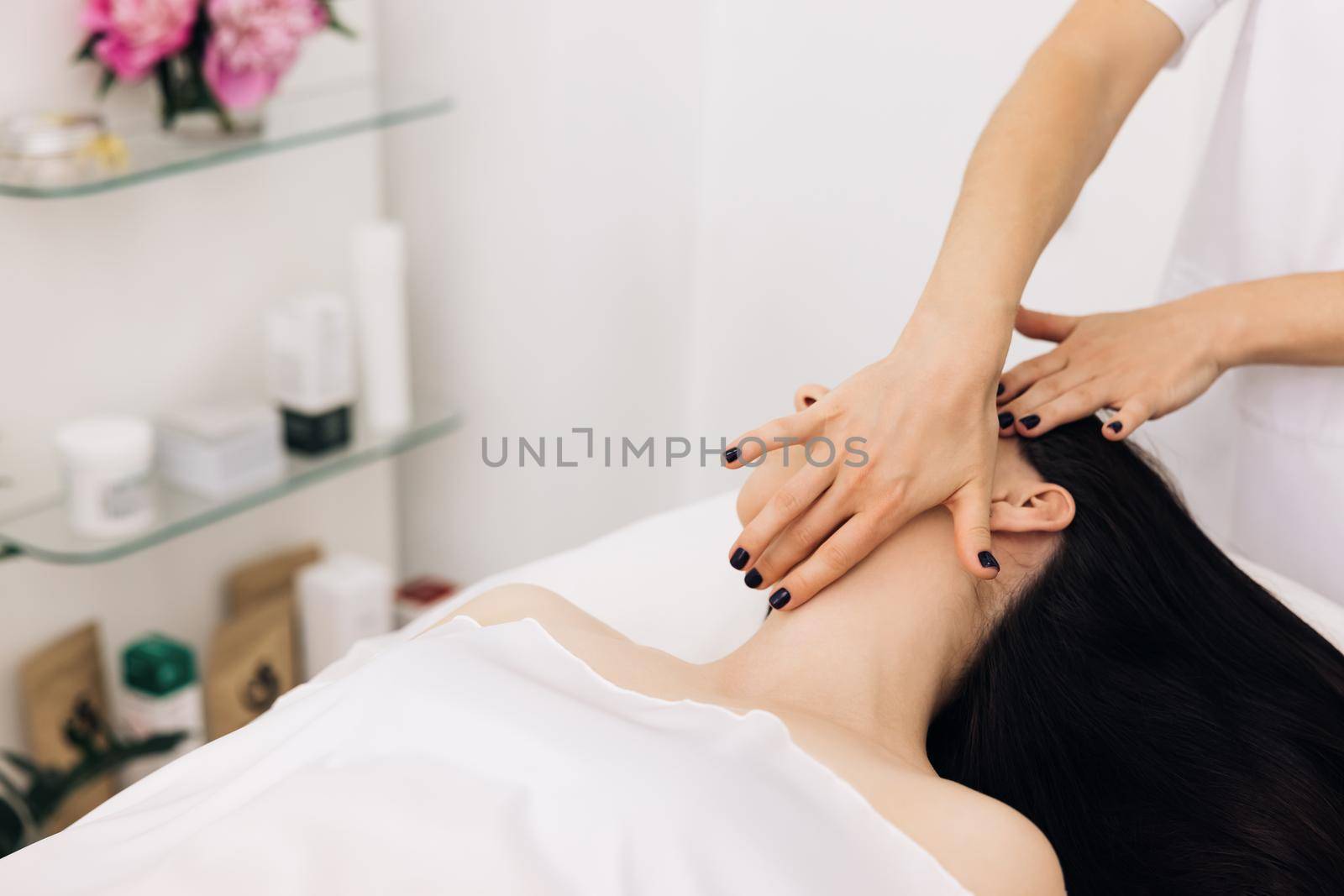 Caucasian woman receiving a facial massage at an aesthetic salon. Face Massage in beauty spa salon. Spa facial Massage. Body care, skin care, wellness, wellbeing, beauty treatment concept.