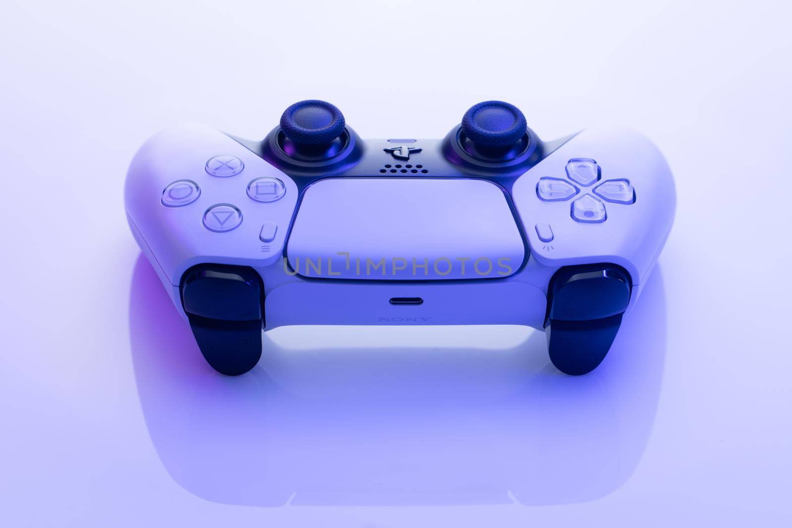 NEW YORK - March 3, 2021: Sony Playstation 5 controller. White controller from TV game box in blue light. One white game controller for Sony Playstation 5. by uflypro
