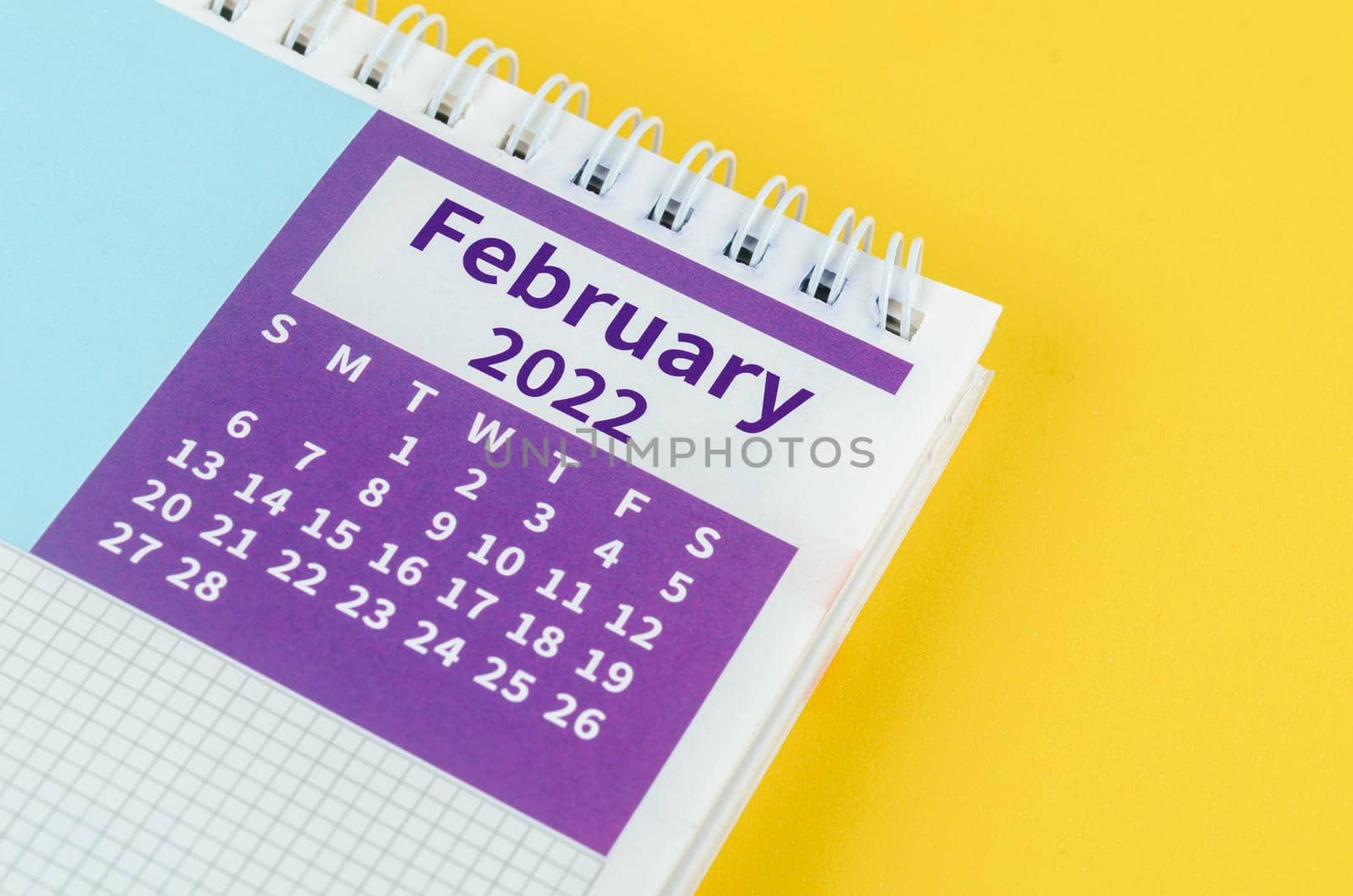 The February 2022 desk calendar on yellow background.