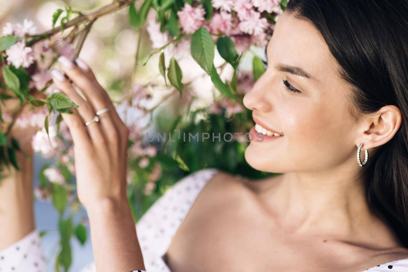 Portrait of a Gorgeous Dark Haired Hispanic Woman Charmingly while Standing in the Middle of Modern Urban City Landscape, Wearing White Dress. Young Woman Enjoys Life by uflypro