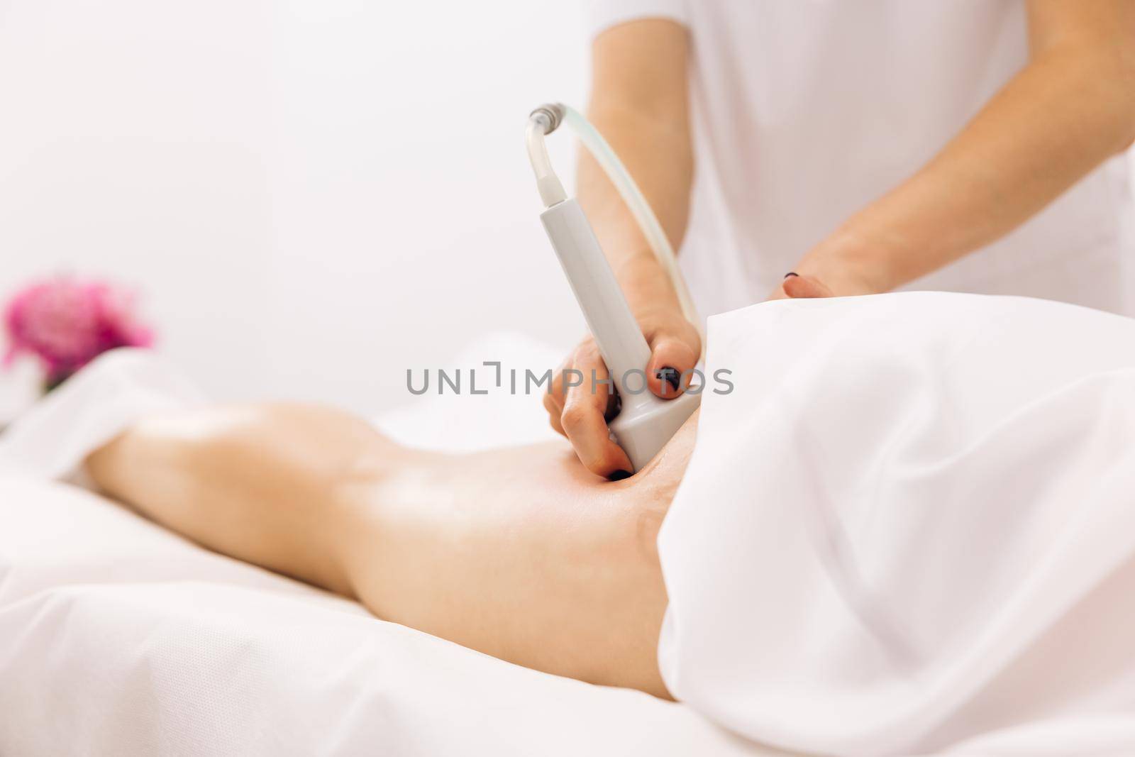 Woman getting anti-cellulite and anti-fat therapy. Female physiotherapist doing an anti-cellulite can massage of the buttocks and hips of a young woman. Care and maintenance of the health concept
