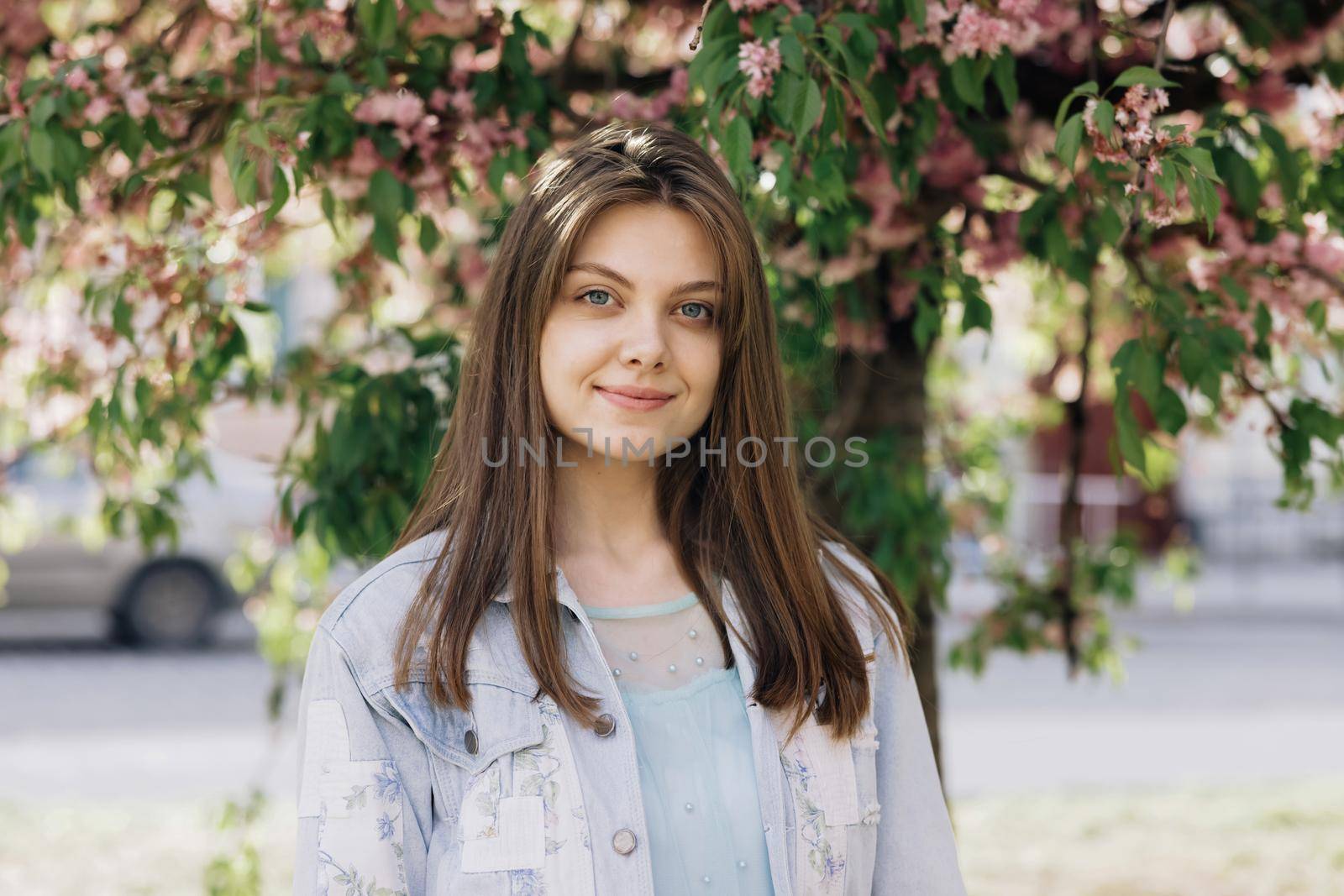 Smiling young woman in outfit looking to camera outside on street feel happy girl portrait beautiful modern woman pretty. by uflypro