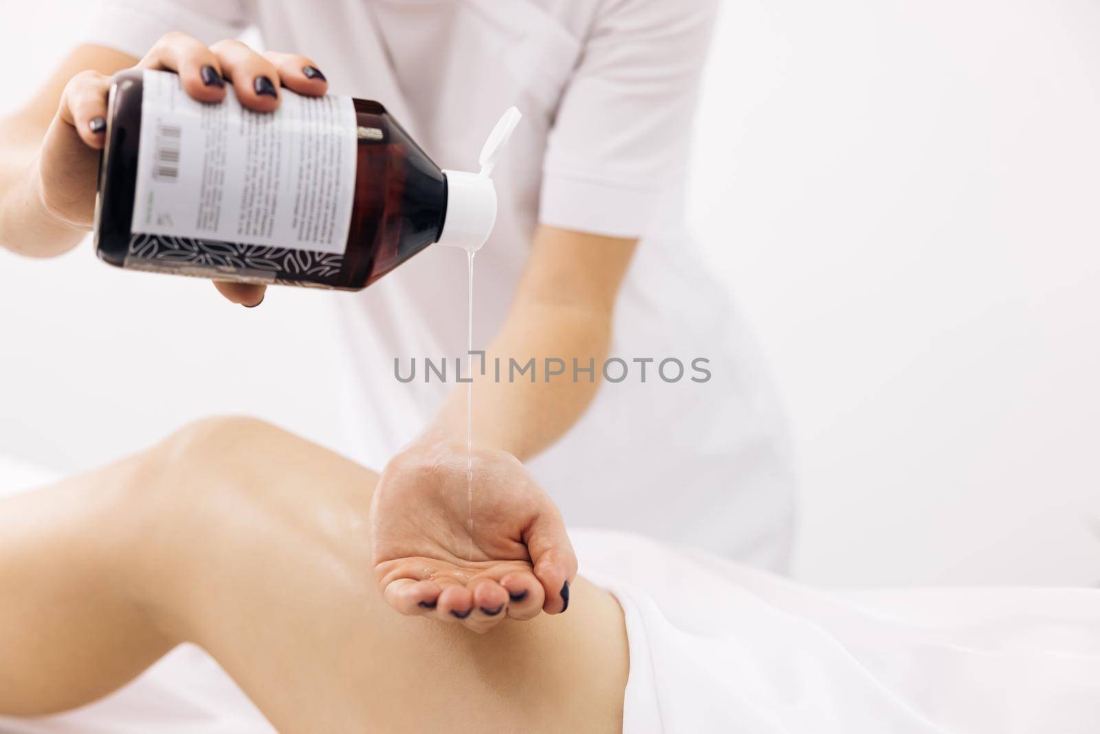 Close up Therapeutic massage of the female leg. Female hands doing professional massage to a woman on a massage table. Beauty treatments.