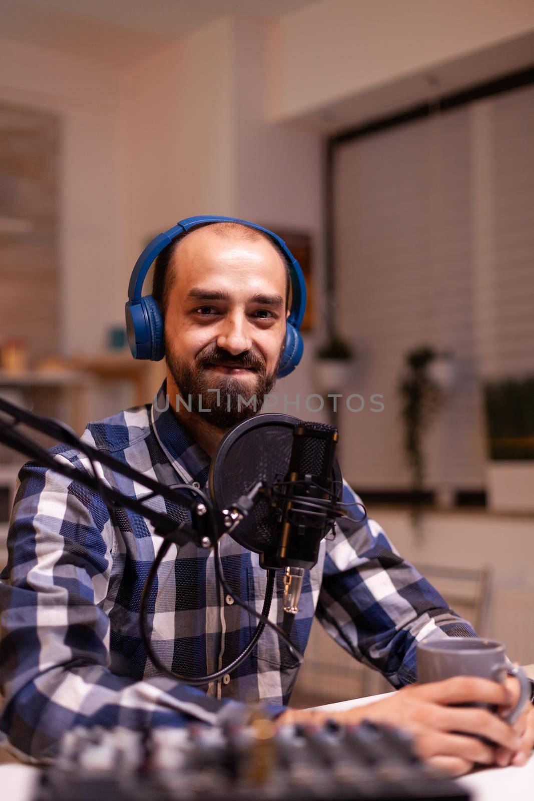 New media star smiling announcing contest winner during his live podcast in home studio using professional gear. Creative online show On-air production internet broadcast host streaming live content