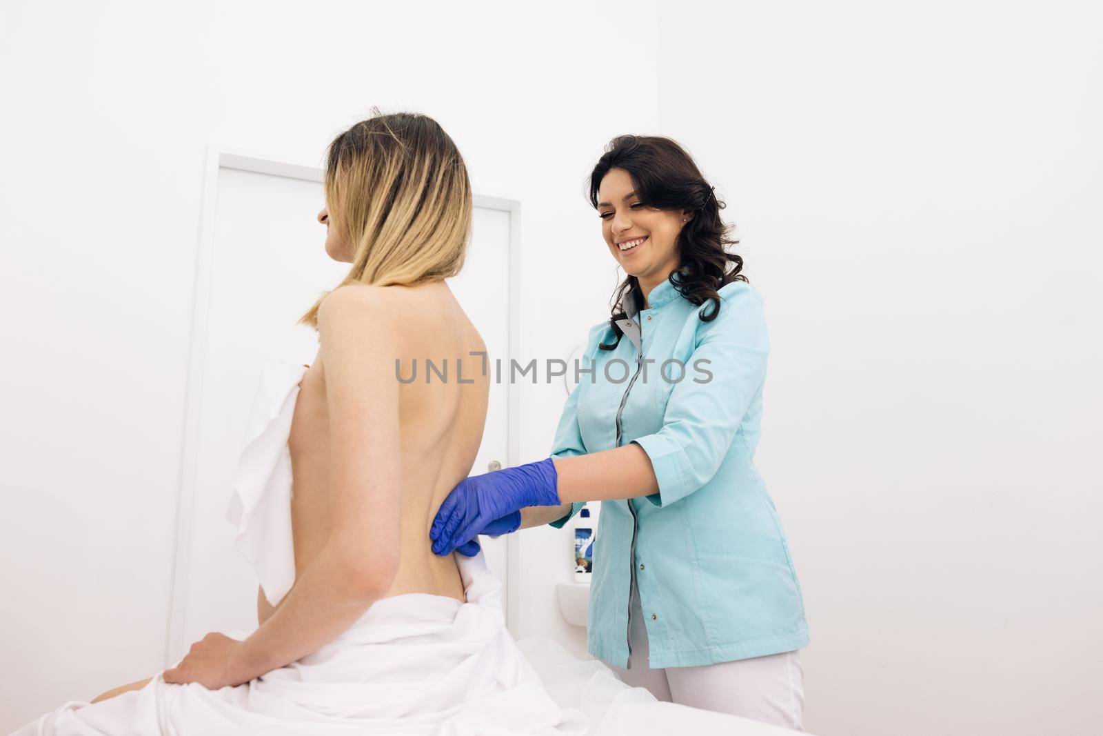 Girl receives a physiotherapy massage during a session. Alternative medicine treatment and rehabilitation of patients. The chiropractor regulates the patient's shoulder by uflypro