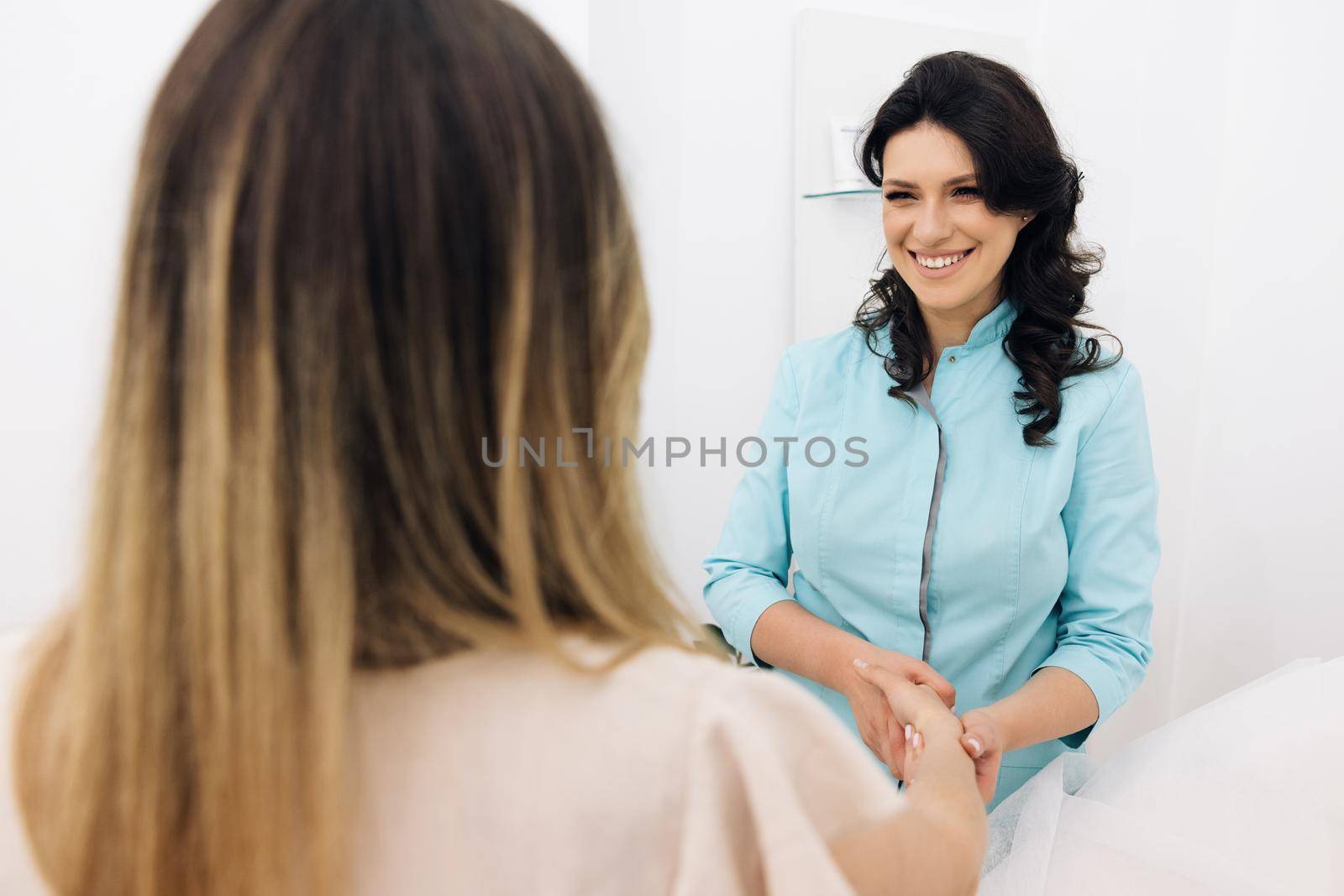 Female medical assistant wears blue coat talking to patient. Modern rehabilitation physiotherapy worker with woman client. Physiotherapy Improves the Patient's Quality of Life. by uflypro