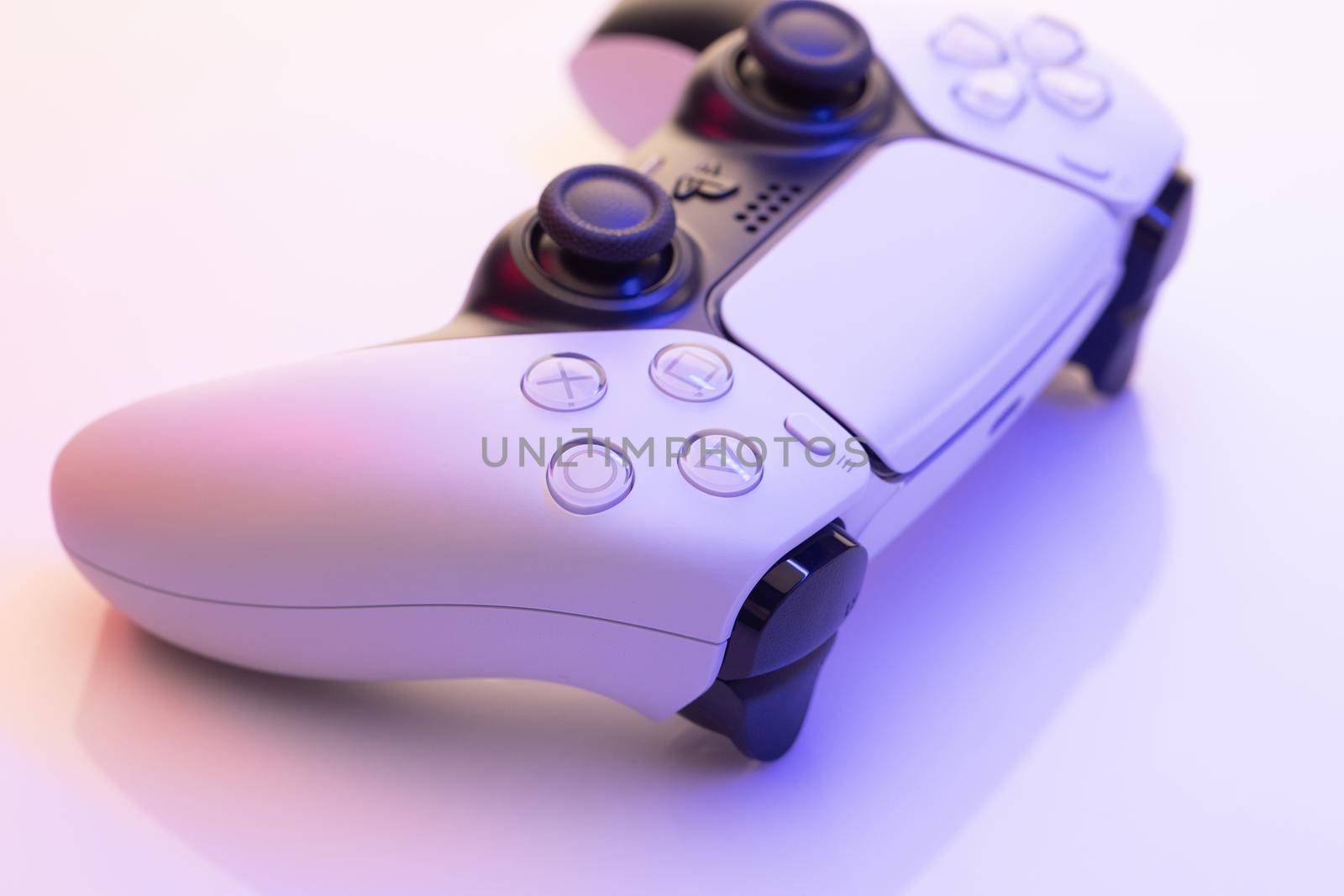 NEW YORK - March 3, 2021: Sony Playstation 5 controller. Close up parts of joystick from new Sony PlayStation 5 set-top box. White controller from TV game box in blue light by uflypro