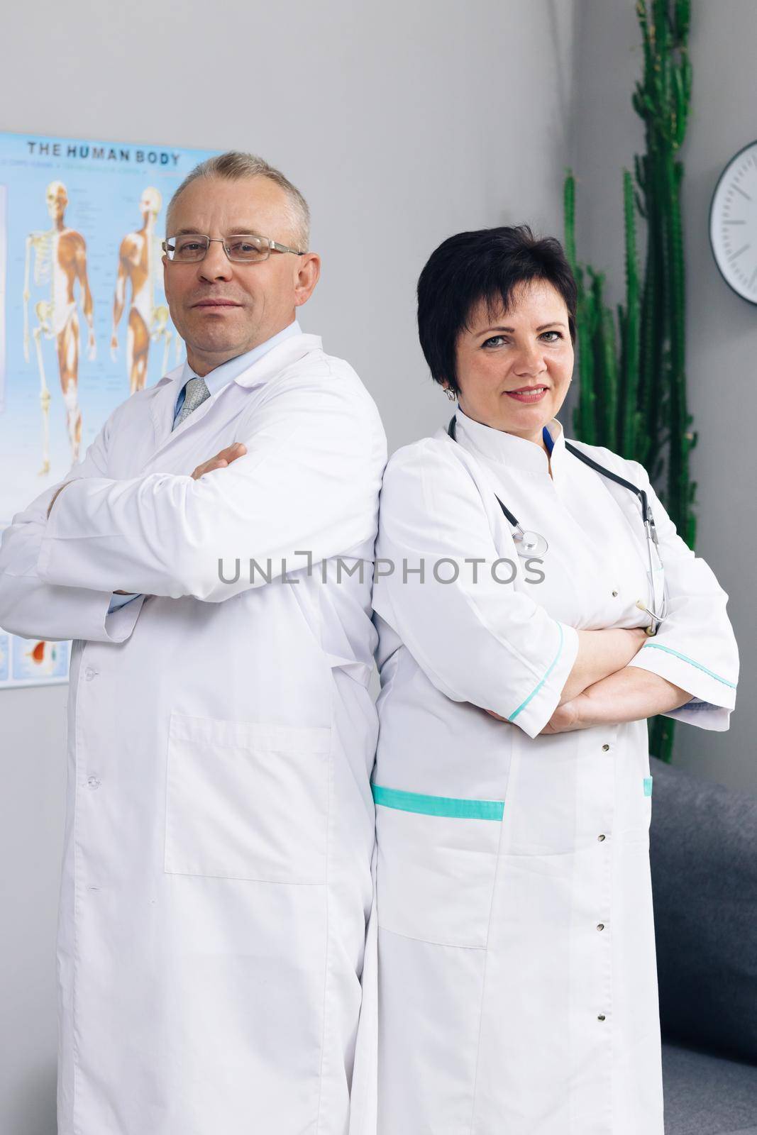 Portrait Of Medical Team Standing In Modern Hospital Building. Physicians and nurses looking at camera. Clinic team. Docs at work in hospital by uflypro