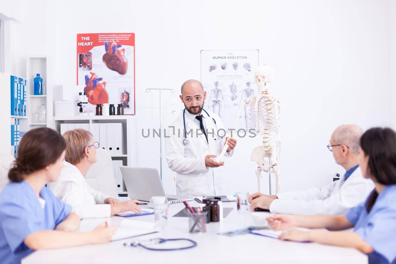 Doctor making presentation to medical staff in hospital radiology area. Clinic expert therapist talking with colleagues about disease, medicine professional