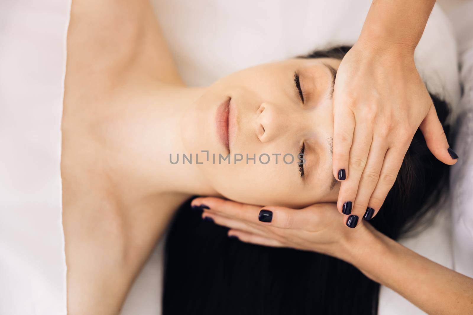 Face Massage in beauty spa salon. Spa facial Massage. Beauty Treatments. Body care, skin care, wellness, wellbeing, beauty treatment concept by uflypro