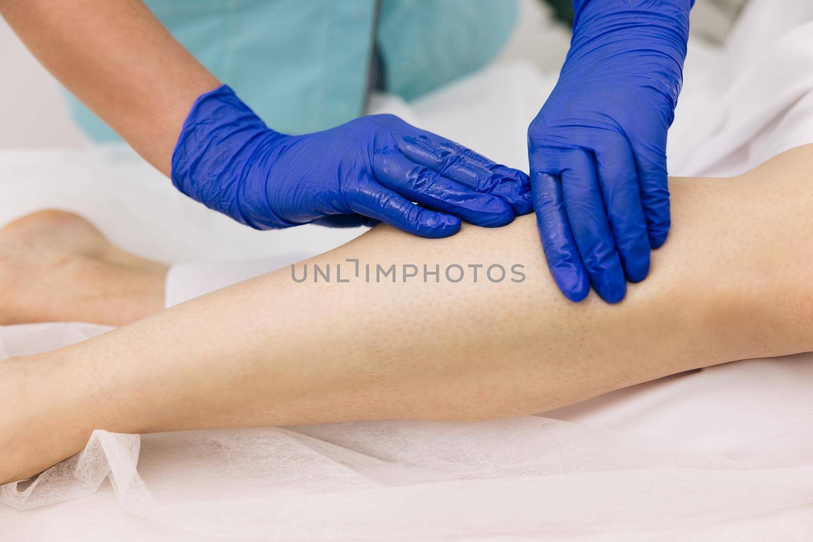 Doctor in gloves examining painful knee of female patient leg trauma. Healthcare medical insurance concept. Physiotherapist worker woman assisting physical medical exercise recovery after injuries.