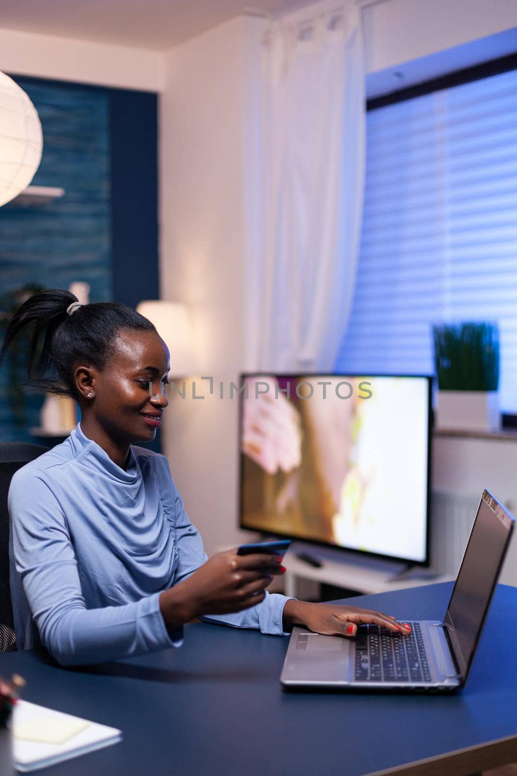 Dark skinned woman making online transaction by DCStudio