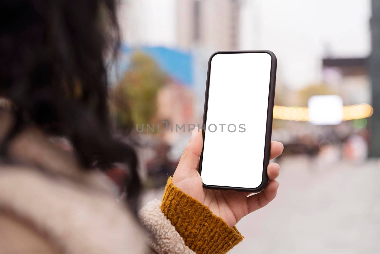 woman holding blank smartphone outside. High resolution photo