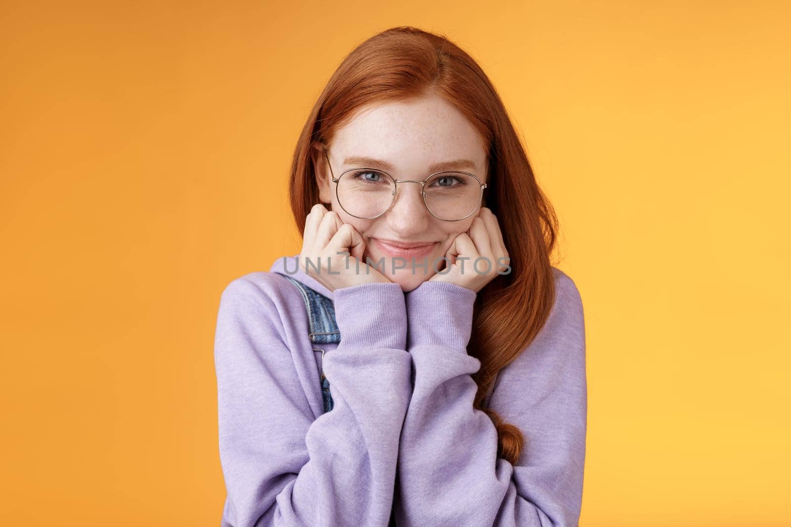 Lovely cute redhead sweet silly girl geek university student wearing glasses lean hand smiling tenderly look affection adore listen sensual confessions boyfriend, standing orange background by Benzoix