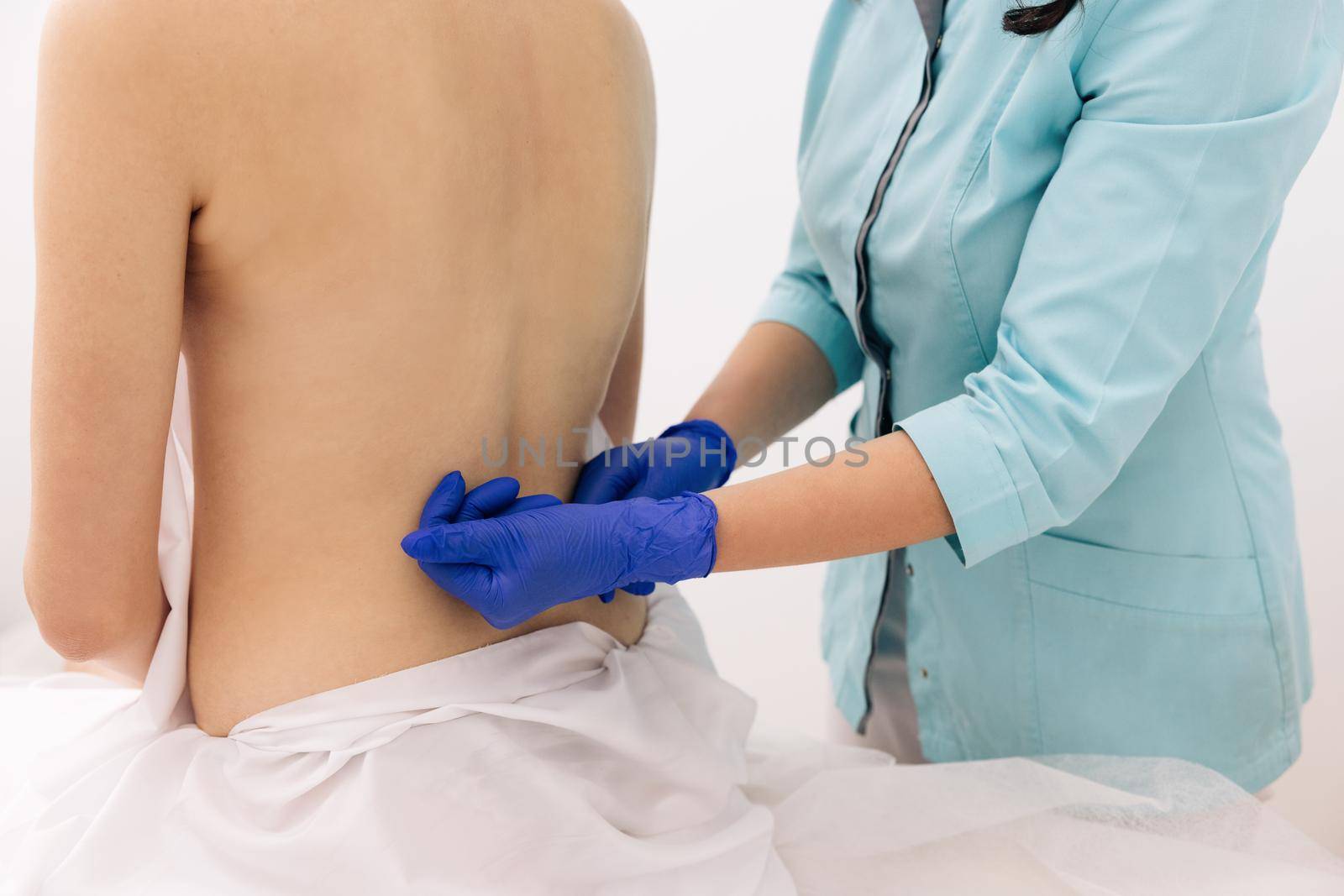 Modern rehabilitation physiotherapy worker with woman client. Chiropractor massaging female shoulder on white background. Rehabilitation. Treatment concept.