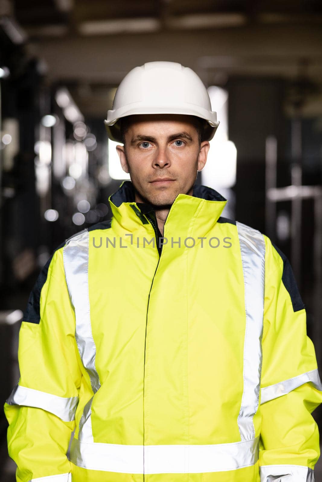 Portrait of caucasian heavy industry engineer worker posing confident to camera wearing hardhat and uniform. Business people in hard hat or safety wear. Electrician, electric worker by uflypro