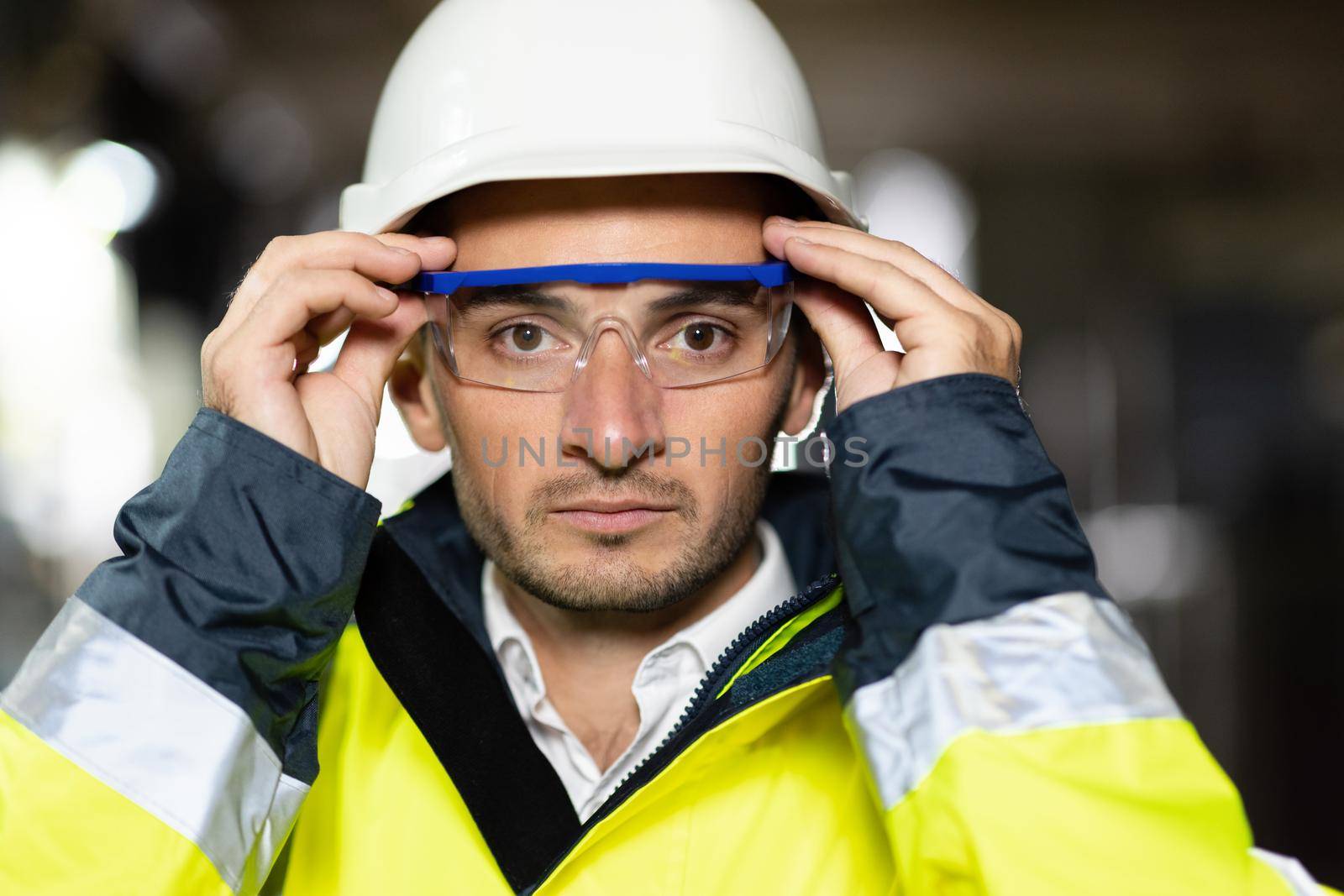 Closeup of Professional Confident Serious Engineer Looking at Camera, Wearing Safety Uniform and Goggles Standing at Heavy Industry Factory Ready to Manufacturing Works During Metal Welding by Staff by uflypro