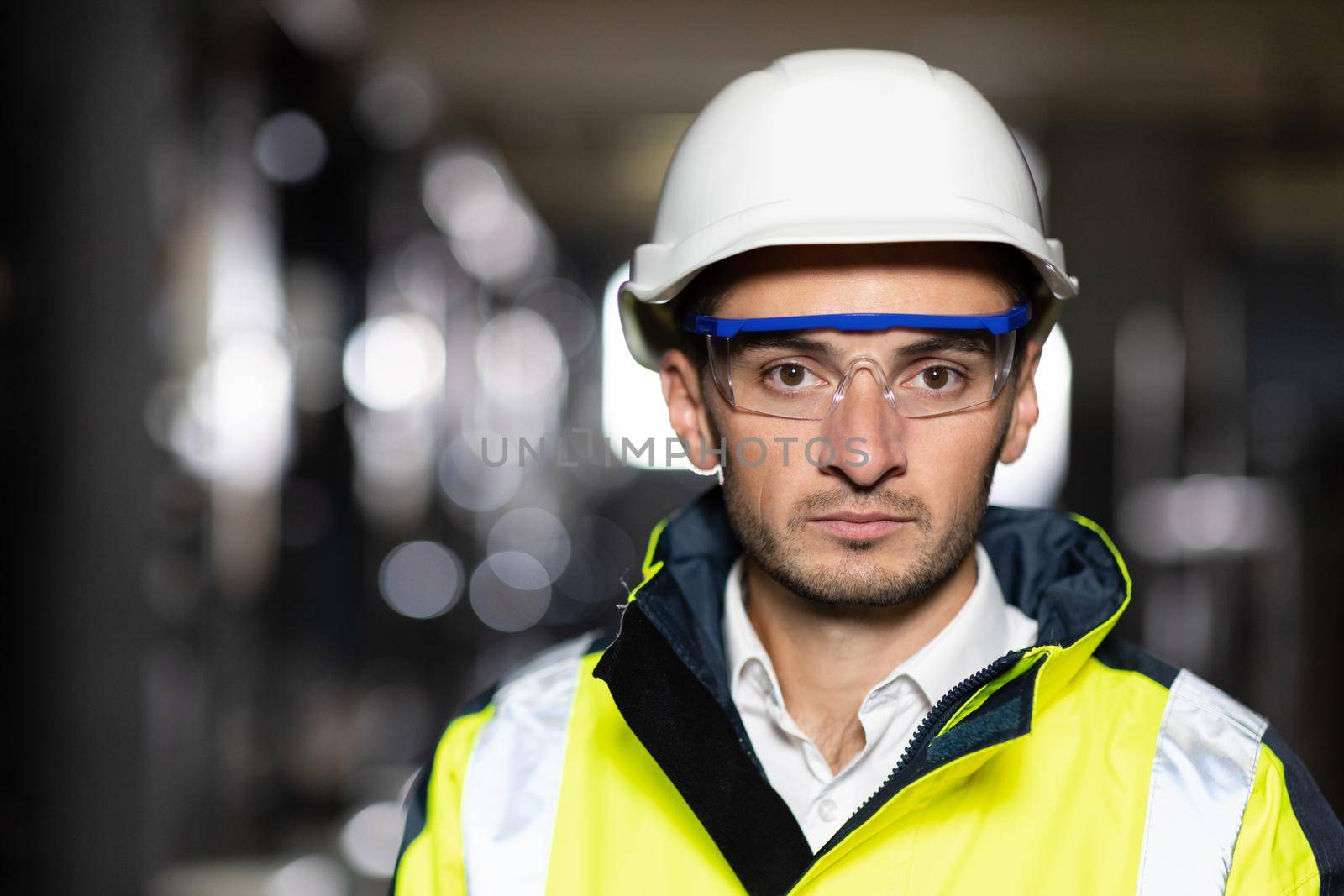 Professional Confident Serious Engineer Looking at Camera, Wearing Safety Uniform and Goggles Standing at Heavy Industry Factory Ready to Manufacturing Works During Metal Welding by Staff.