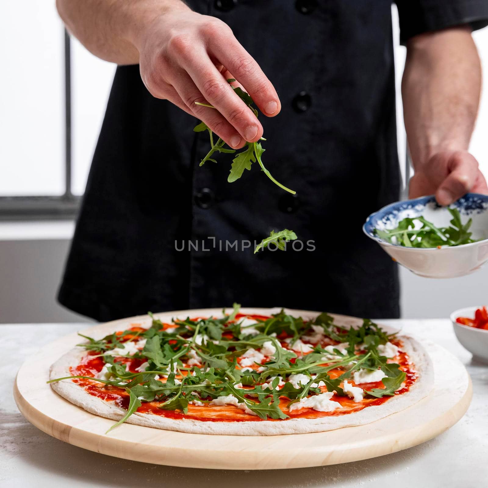 man putting arugula pizza dough. High quality photo by Zahard