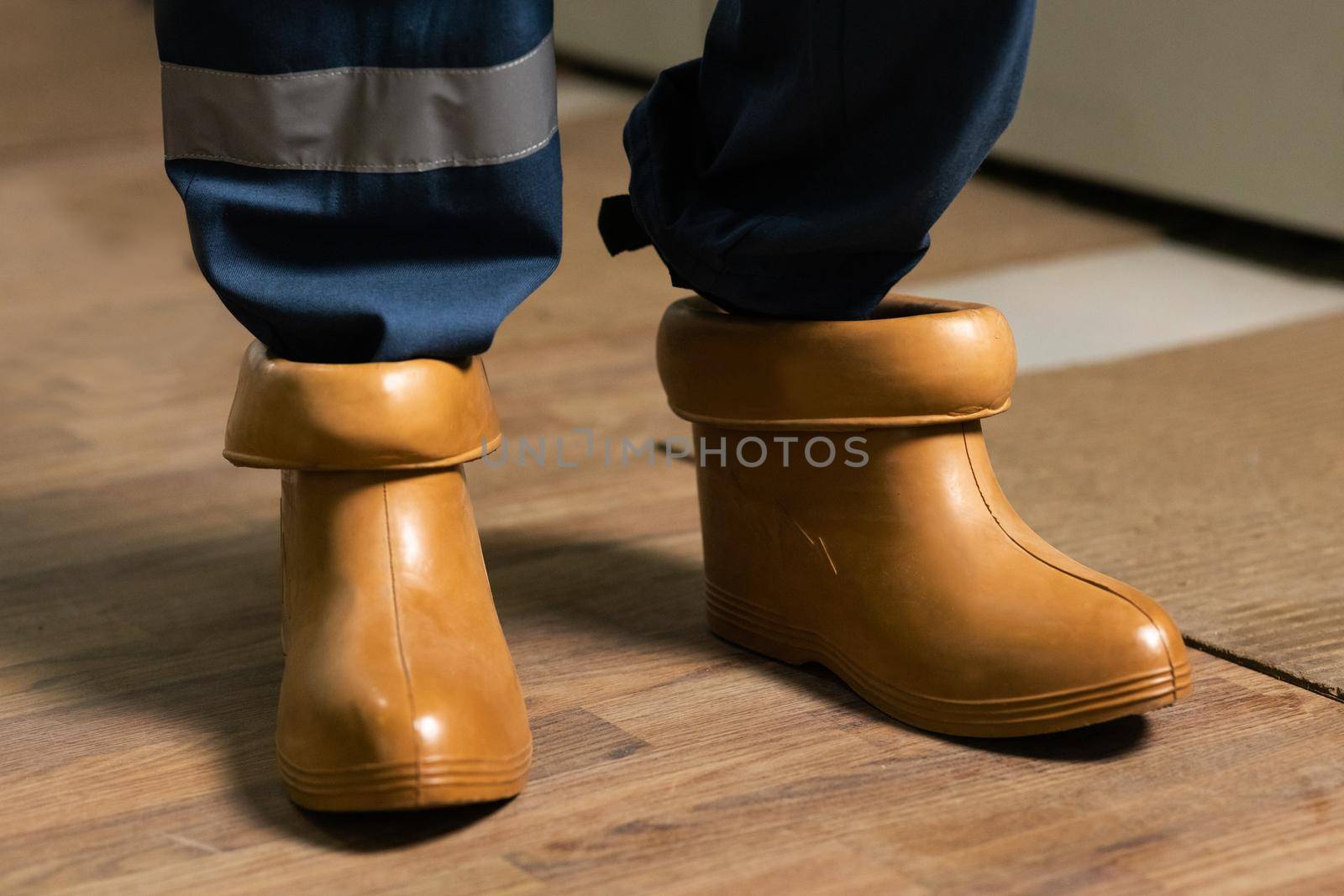 High voltage power station. Electrician wears rubber boots. Electrical technician is putting on special protective shoes. Concept of electric power station development.