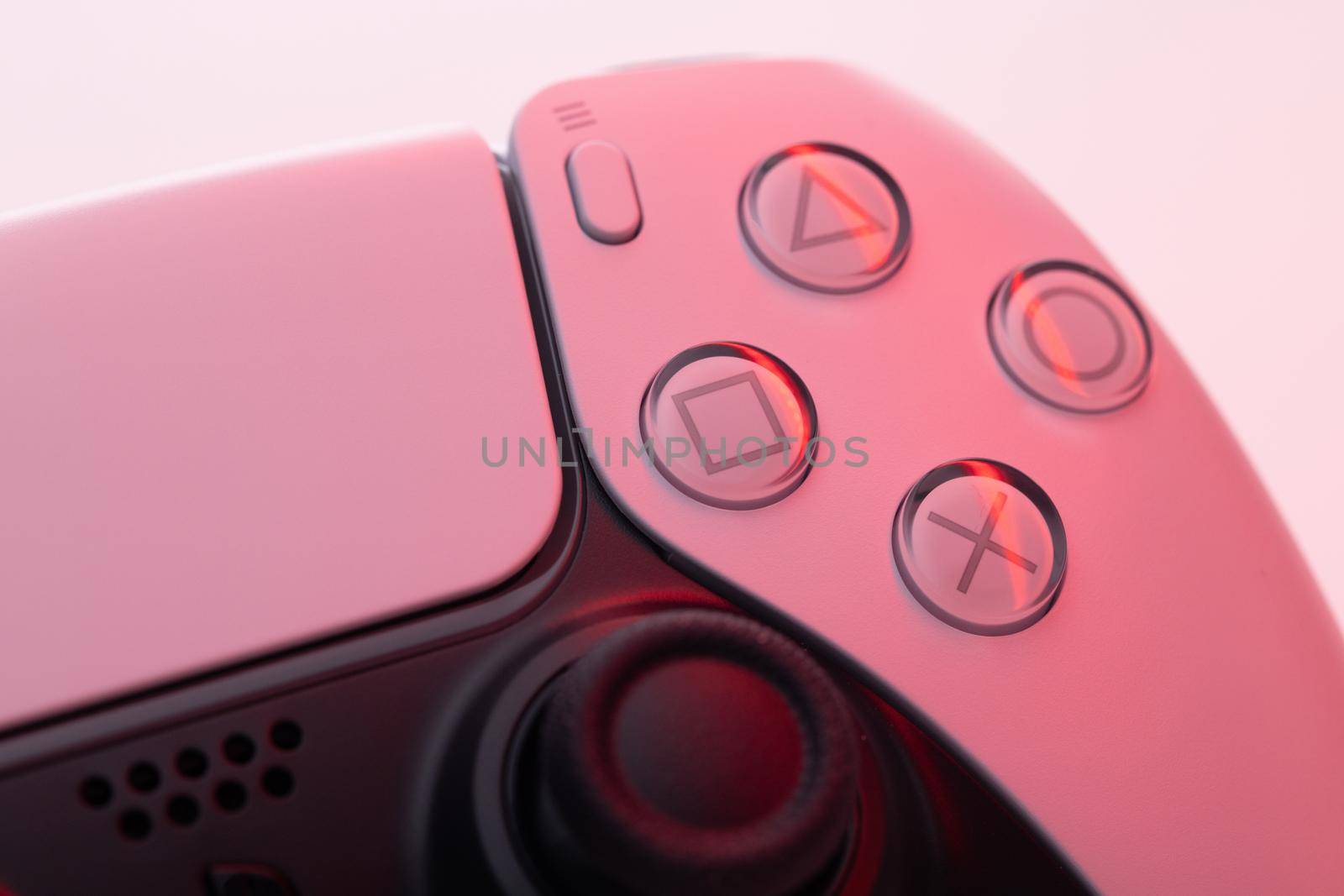 Lviv, Ukraine - February 27 2021: Close up parts of joystick from new Sony PlayStation 5 set-top box. White controller from TV game box in red light by uflypro