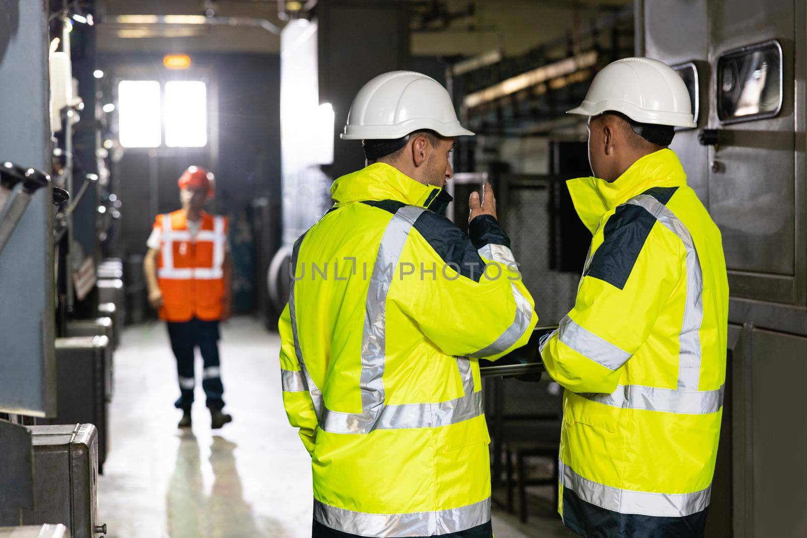 Facility for Construction of Oil, Gas and Fuel Pipeline Transportation Products. Two Heavy Industry Engineers Stand in Pipe Manufacturing Factory, Use Digital Tablet Computer, Have Discussion.