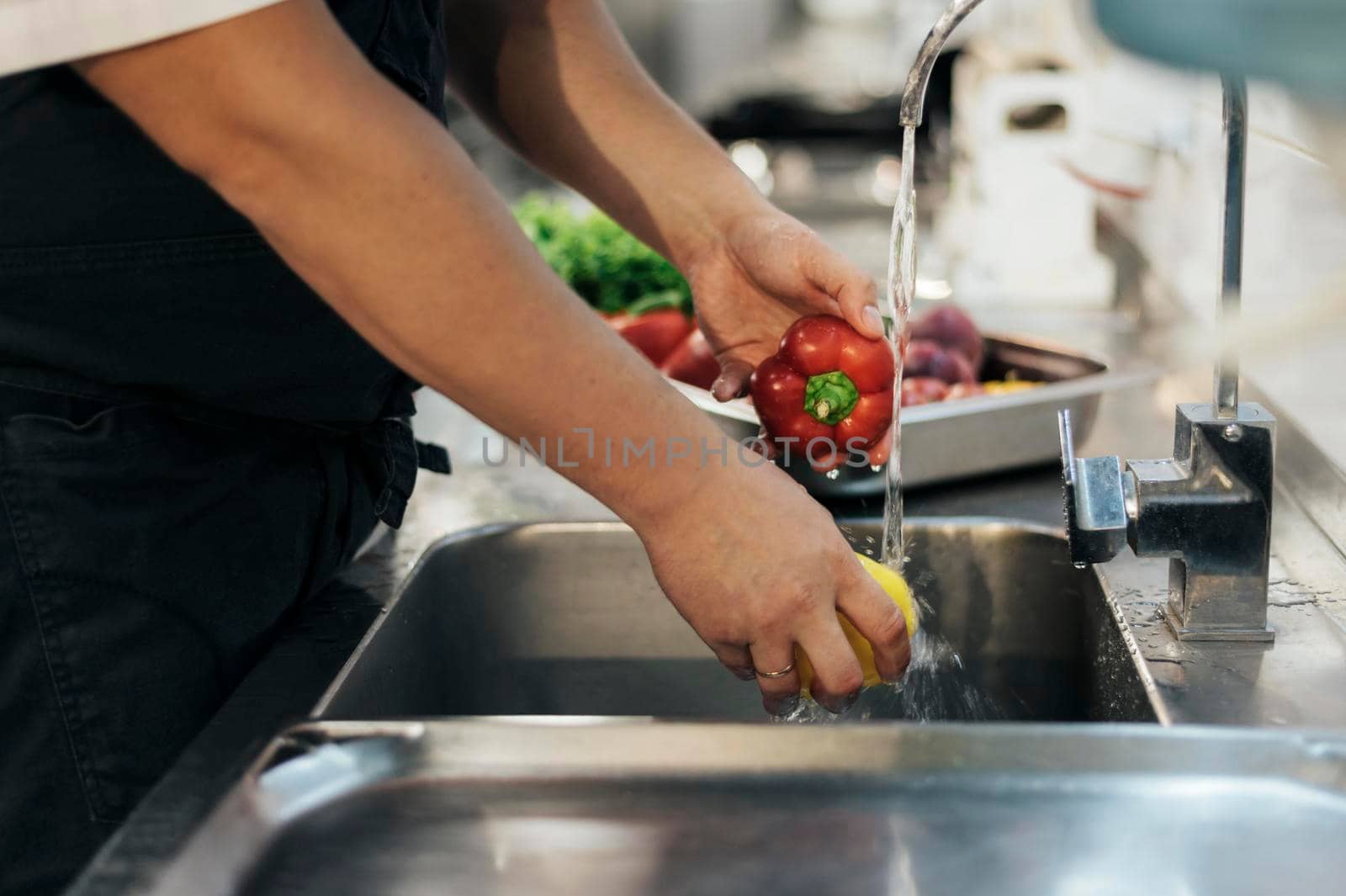side view male chef washing vegetables. High resolution photo